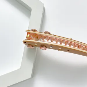 Barrette banane élégante en acétate rose avec strass et motif floral évidé chic