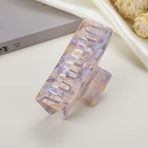 Macro detail of rectangle purple marbled acetate hair claw clip with jagged grip teeth