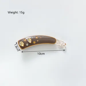 Détail de la pince banane en acétate de 10 cm avec cristaux et touches florales dorées