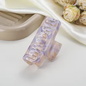 Detalle de pinza para el pelo de acetato con textura marmoleada en violeta y amarillo