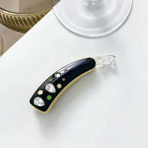 Détail d'une pince banane avec strass colorés et boucle spirale transparente