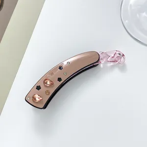 Détail d'une pince banane avec cristaux champagne et motifs floraux noirs