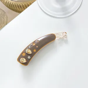 Détail de la pince banane en résine café avec strass et motifs floraux découpés