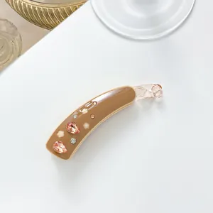 Détail de la pince banane en acétate avec cristaux roses et motifs floraux ajourés