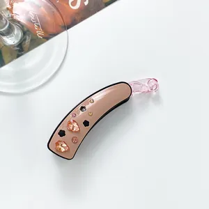 Vue détaillée de la pince à cheveux banane avec strass champagne et finition acétate