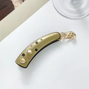 Détail de la pince banane en acétate avec cristaux de champagne et motif trèfle