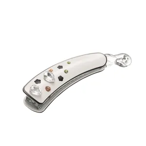 Barrette banane blanche en acétate avec strass en goutte et motif fleuri évidé