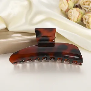 Detalle de una pinza de pelo grande de carey sobre una elegante tela de seda crema