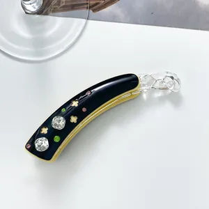 Detail of 10cm acetate banana hair clip with sparkling rhinestones and clover cutouts
