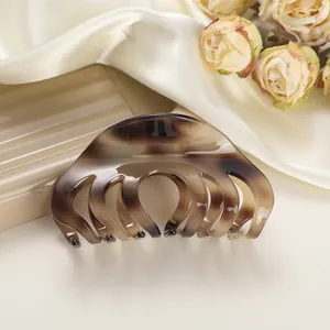 Detail van schildpad-acetaat haarklem op zijde met gedroogde rozen decoratie