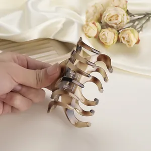 Elegante haarklem van acetaat met schildpadpatroon en goudkleurige metalen veer detail