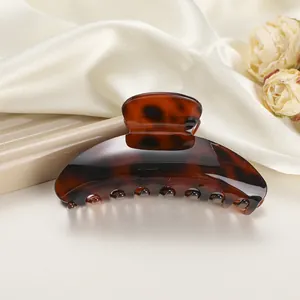 Close-up of elegant leopard print hair claw clip with glossy brown tortoiseshell texture