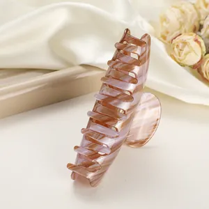 Detail of pink and brown marbled hair claw clip on soft satin with floral accents