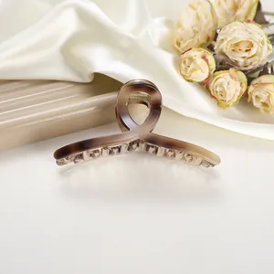 Macro view of large tortoiseshell hair claw clip with ribbon design and gold spring