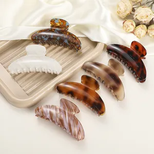 Close-up of leopard print hair claws in various marble textures on a soft satin fabric