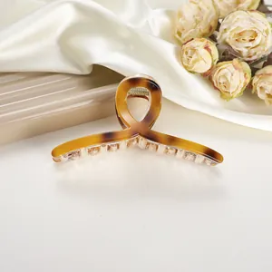 Detail showing high-quality tortoiseshell claw clip with a stylish crisscross design