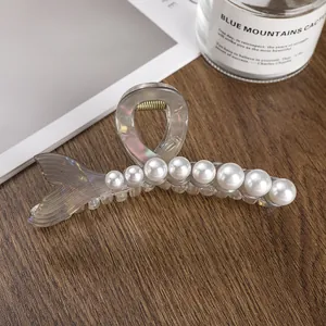 Detail of mermaid tail hair claw clip in translucent grey with gradient faux pearls