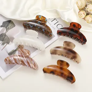 Detailed set of large leopard and marble pattern hair claws on white silk and dried flowers