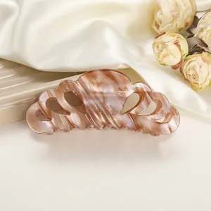 Detailed macro view of the marble texture and hollow cutout on this acetate hair claw clip