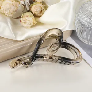 Detailweergave van de amberkleurige hartvormige haarklem op elegante zijden achtergrond