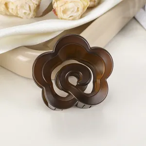 Détail d'une pince à cheveux fleur ambrée translucide sur fond beige doux