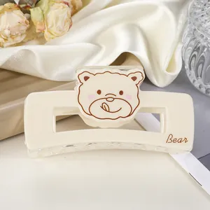 Détail d'une pince à cheveux rectangulaire blanc crème avec un motif d'ours mignon
