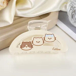 Detail view of cream hair claw clip with cute kitten cartoon patterns and kitten text