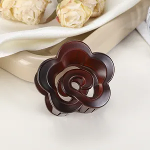 Vue détaillée de la pince à cheveux fleur ambre sur soie avec roses élégantes