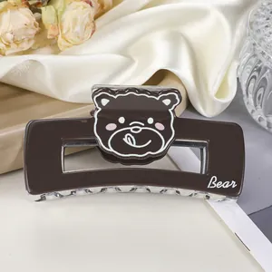 Détail d'une adorable pince à cheveux ours brun en acrylique sur soie blanche