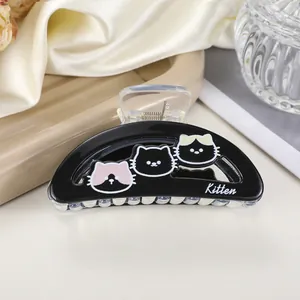 Macro shot of black kitten hair claw clip with colorful cartoon cats and Kitten text