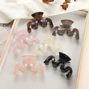 Set of wavy jelly hair claws in six colors displayed on a wooden tray with silk fabric