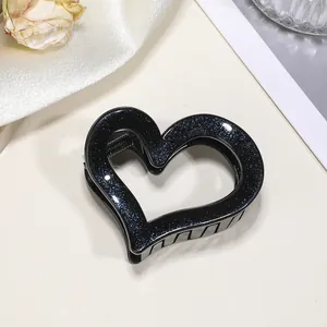 Dettaglio della molletta a cuore per capelli con glitter blu e molla interna nera