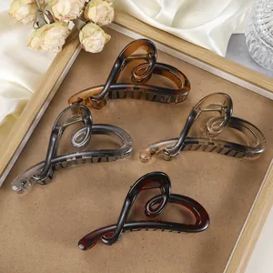 Detailweergave van hartvormige haarklemmen van hars in amber en donkerbruin op zijde stof