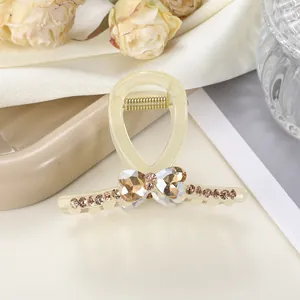 Detalle de pinza para el pelo amarilla con diamantes champagne y corazones