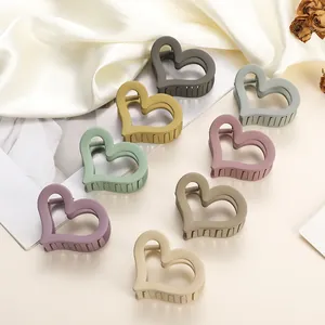 Set of 8 heart-shaped matte hair claws in various pastel colors for stylish buns