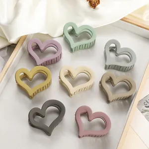 Set of eight matte heart-shaped hair claws in various Morandi colors on a grey tray