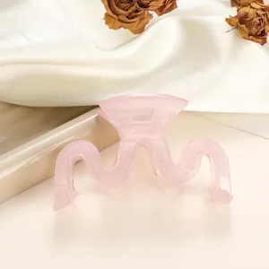 Close-up of a wavy pink jelly claw clip with a sleek matte finish and metal spring detail