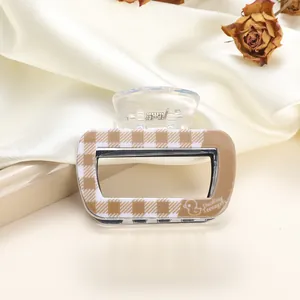 Close-up of a small square checkerboard acrylic hair claw with a transparent spring