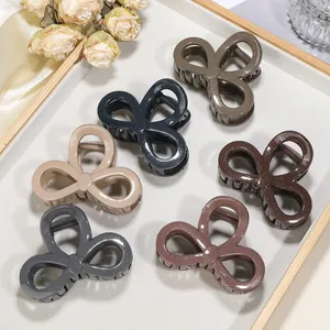 Detailed set of six flower shark clips with subtle glitter finish on a white tray