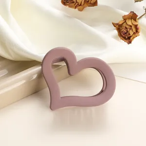 Detailed macro of mauve matte heart hair claw with non-slip teeth and hollowed design