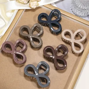 Detailed view of six bow-shaped claw clips in Morandi colors with glitter finish