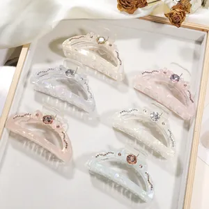 Detail of 6-piece transparent claw clips with pearl luster and floral rhinestone accents