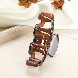 Detail of amber translucent jelly hair claw clip with glossy finish on satin background