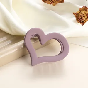 Detail of matte purple heart hair claw clip on silk fabric with floral decor