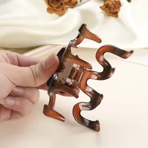 Detail of amber tortoiseshell hair claw clip with smooth resin finish and metal spring