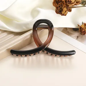 Detailed close-up of amber resin hair claw clip with glossy finish and metal spring