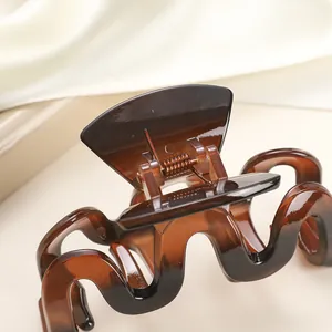 Detailed view of the amber jelly hair claw clip with a wavy design and smooth texture