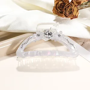 Detail of 9cm iridescent hair claw clip with white flowers and sparkling rhinestones