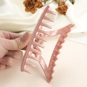 Detail of pink large triangle hair claw clip with strong metal spring and glossy finish
