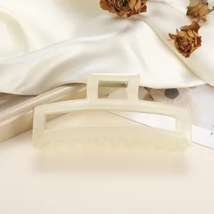 Detailed view of cream square hair claw clip on silk fabric with dried flowers